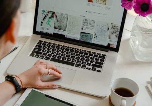Creative work session featuring a woman using a tablet and laptop for design projects.